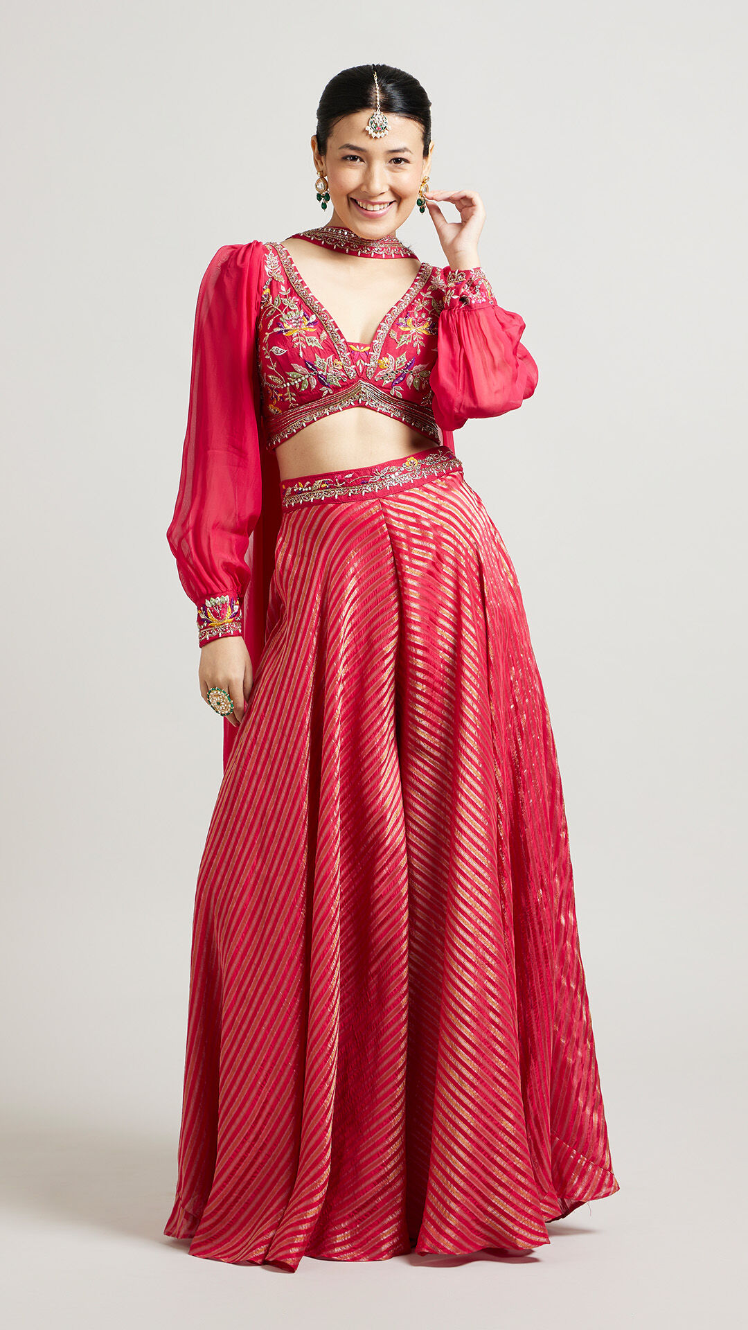 A pretty woman in an elegant red Indo-Western lehenga